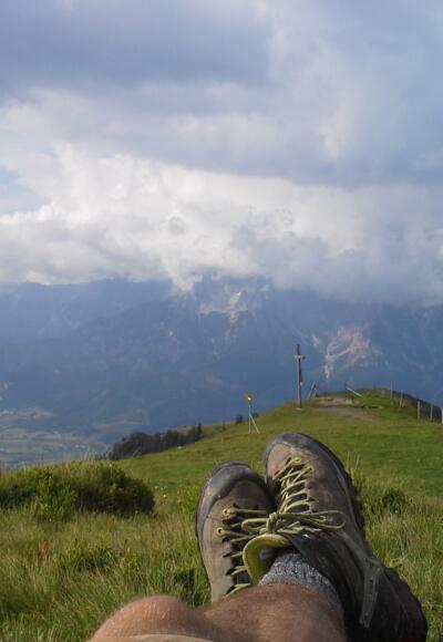 Gipfelrast mit Blick aufs Wolkenverhangene Steinerne Meer und Saalfelden. 