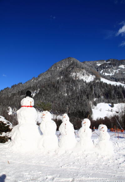Schneemannfamilie am Weg
