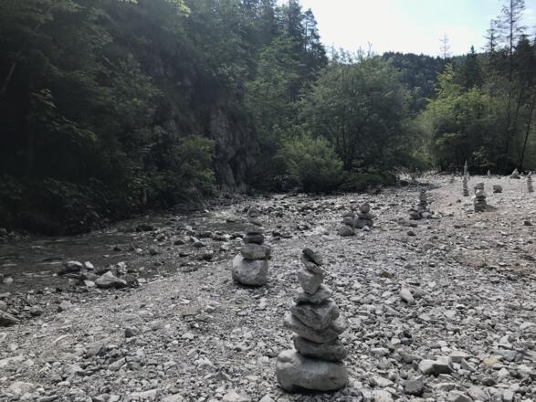 Steinskulpturen säumen den Bachlauf