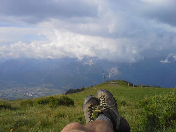Gipfelrast mit Blick aufs Wolkenverhangene Steinerne Meer und Saalfelden. 