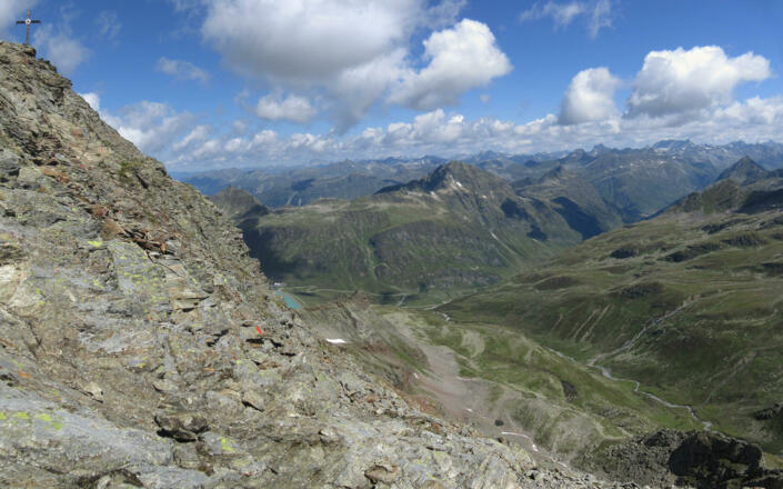 Mit Blick auf das Gipfelkreuz verläuft der Weg im Fels.