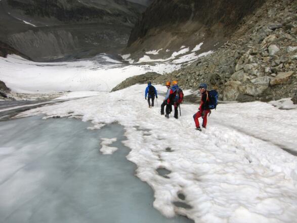 Abstieg am rechten (nördlichen) Gletscherrand bis zum dem Felskopf in Bildmitte.
