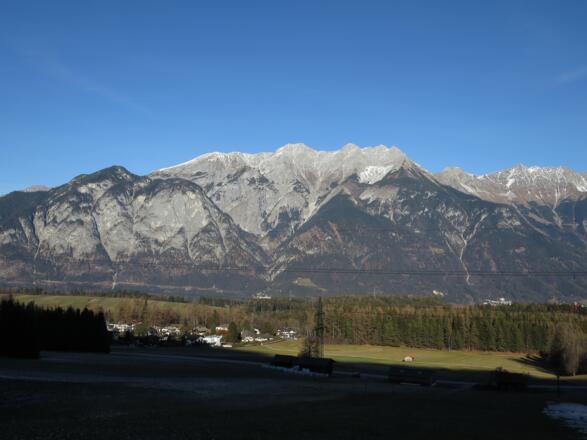 Die Kranebitter Klamm (Bildmitte), links vorne der Hechenberg, hinten Großer und Kleiner Solstein, Hohe Warte und Brandjoch, rechts hinten die Nordkette.