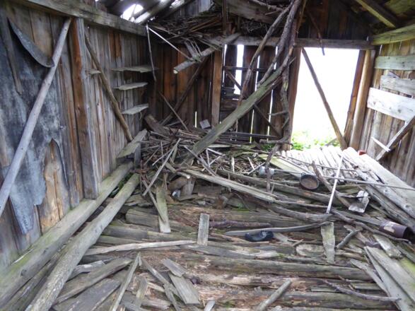 Innenraum der Hütte mit Spuren früherer saisonaler Unterkunft.