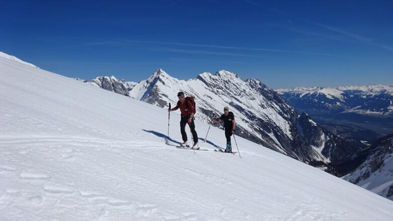 Im oberen Bereich ist auf genügend Abstand zur Gratkante zu achten - Wechten! Hinten der Gratverlauf mit Speckkar Spitze, Großem Bettelwurf und Fallbachkar Spitze. Unten das Halltal, ganz unten das Inntal.