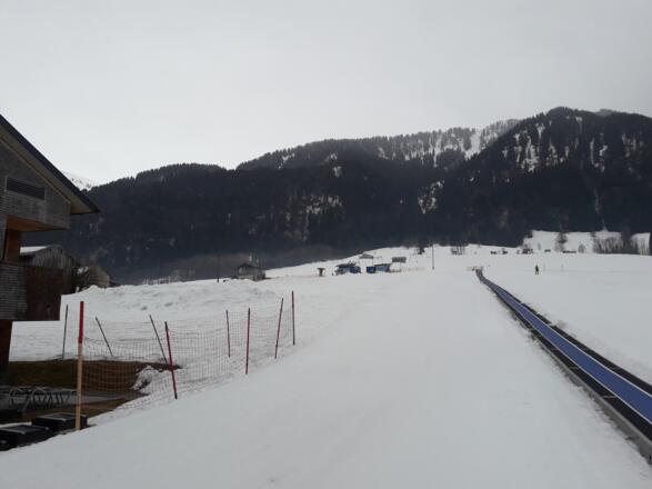 Hier geht es rechts am Skilift nach oben bis zum Waldrand