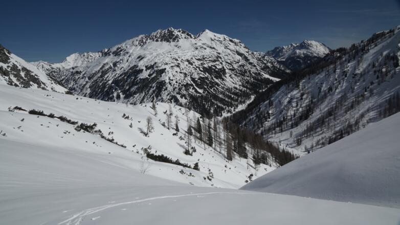 Graben oberhalb der Hinternberghütte, der bei Gleitschneerisiko gemieden werden sollte - dahinter Aserlegruppe