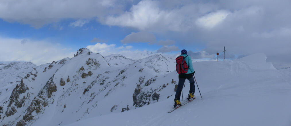 am flachen Gipfelgrat des Mislkopfes, links vom Rauhen Kamm das Pfoner Kreuzjöchl.