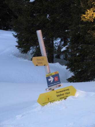 Bei der Schneehöhe verschwinden die Wegweiser fast im Schnee.