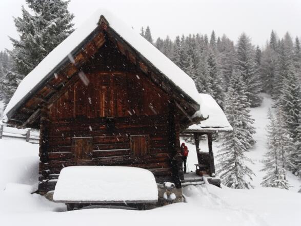 Pause unter dem Vordach der dunklen, &quot;alten&quot; Kocheralmhütte.