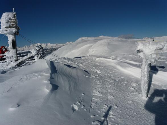 Eisig geht&#039;s zu am Gipfel Teuerlnock, 2145 m, Blick zur Bergstation Aineck, 2210 m.