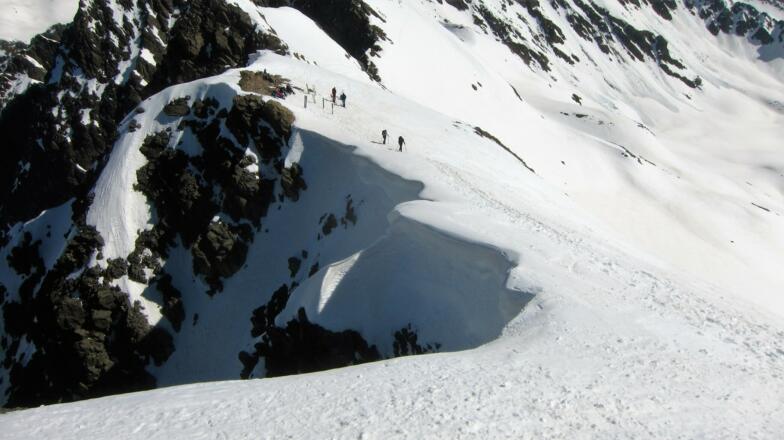 Blick aus der Gipfelflanke hinunter zu Skidepot. Auf der Westseite fälllt das Gelände extrem steil ab - Achtung auf Überwechtung in diesem Bereich!