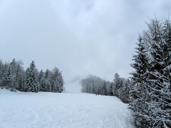 In der Bildmitte im Nebel das Gipfelziel.