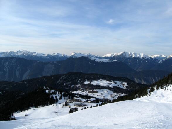 Blick ins Schigebiet. Der zentrale Sammelpunkt, an dem die Lifte von allen Seiten zusammentreffen. Hinten in der Bildmitte, die freien Hochflächen des Simmering.