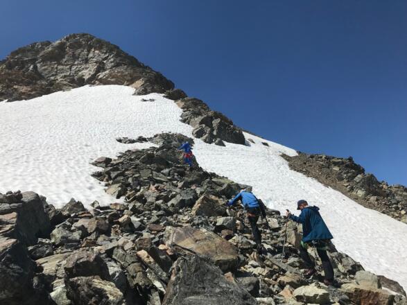 Von der Tiroler Scharte geht es zunächst entweder über das Firnfeld oder etwas links davon im Blockgelände bergauf