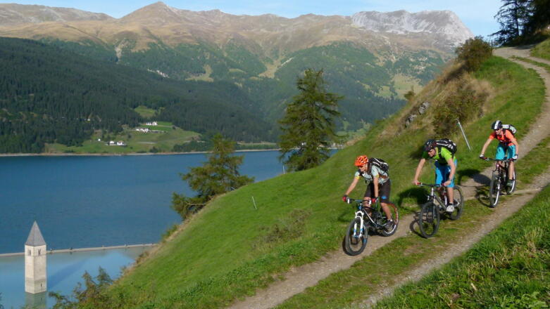 Graun mit Kirchturm im See