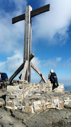 Das hölzerne Gipfelkreuz auf massiven Mauern.