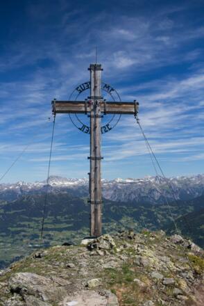 Gipfelkreuz des Schwarzhorns mit Aussicht auf den Bregenzerwald